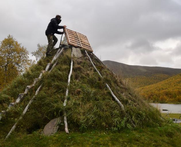 Mikael Vinka stands on top of a traditional goathie home at his Sami Ecolodge near Ammarnas,...
