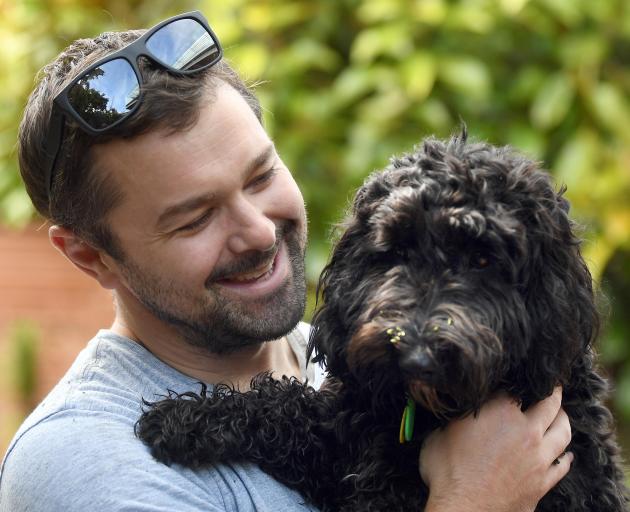 Sybil the spoodle is comforted by Dunedin man Gareth Lea after her big day out on Saturday....