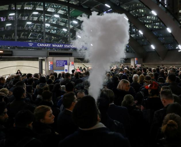 A man smokes an e-cigarette in the queue to Canary Wharf tube station in London. Photo: Reuters 