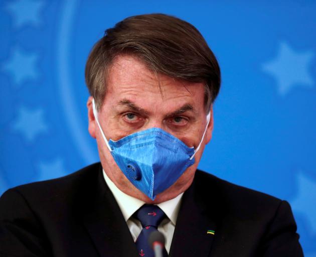 Brazil's President Jair Bolsonaro wears a protective face mask at a recent press conference in...