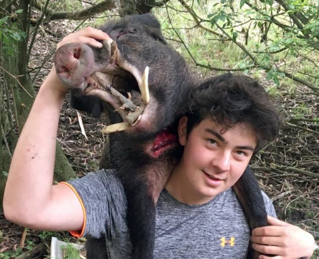 John McGlashan College pupil Caleb Le Cong carries a boar out of the bush during the college’s...