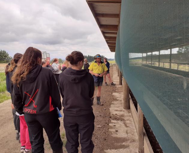 North Otago dairy farmer Jason Hayman (in yellow) shows the school pupils his feed pad. Photos: Supplied
