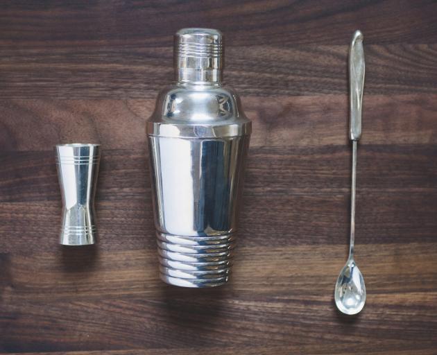 A cocktail shaker with jigger and spoon. Photo: Getty Images