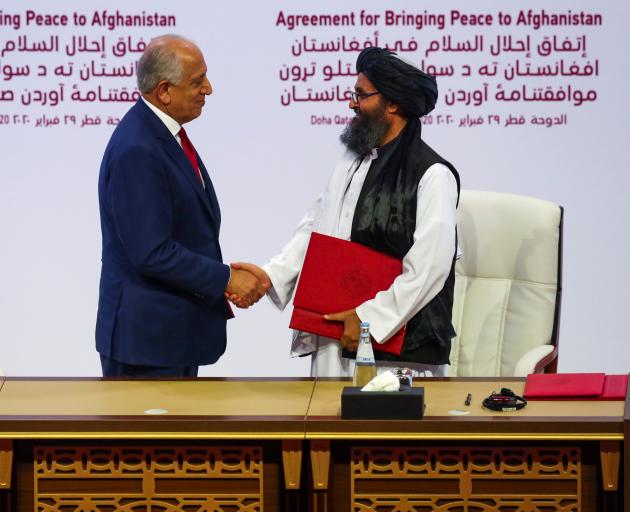 Mullah Abdul Ghani Baradar, the leader of the Taliban delegation, and Zalmay Khalilzad, U.S. envoy for peace in Afghanistan, shake hands after signing an agreement at a ceremony between members of Afghanistan's Taliban and the US. Photo: Reuters