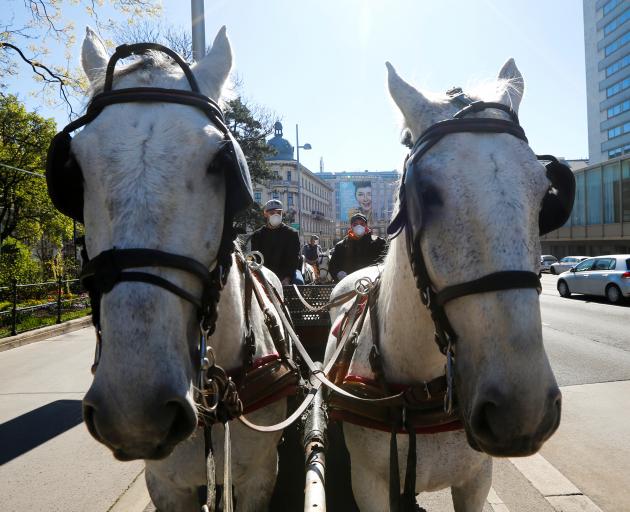 A Fiaker horse carriage waits for food packages for delivery in front of the InterContinental...