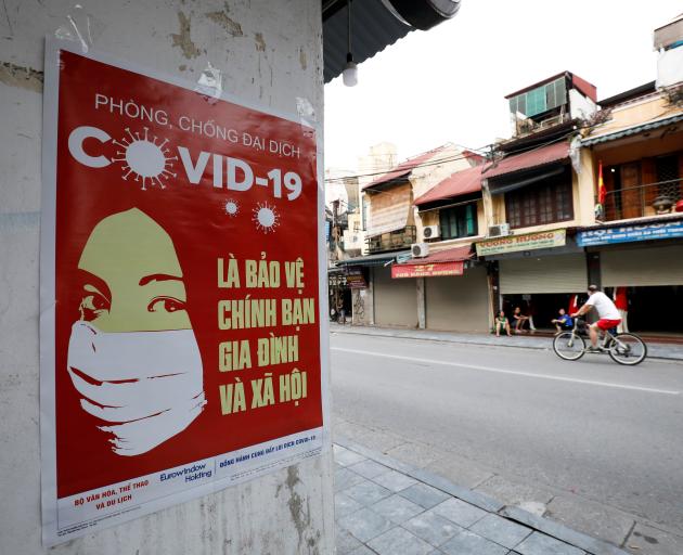 A poster warning about  Covid-19 is seen on a street in Hanoi, Vietnam. Photo: Reuters