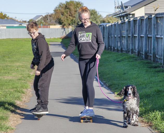 Skateboarding and exercising the dog at the Rawhiti School bike track, New Brighton.