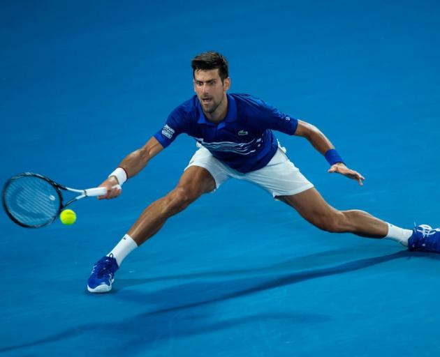 Novak Djokovic reaches for a shot during his win last night at the Australian Open. Photo: Getty...