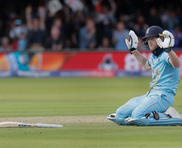 Ben Stokes of England apologises after he dives to make his ground but the ball deflects off his...