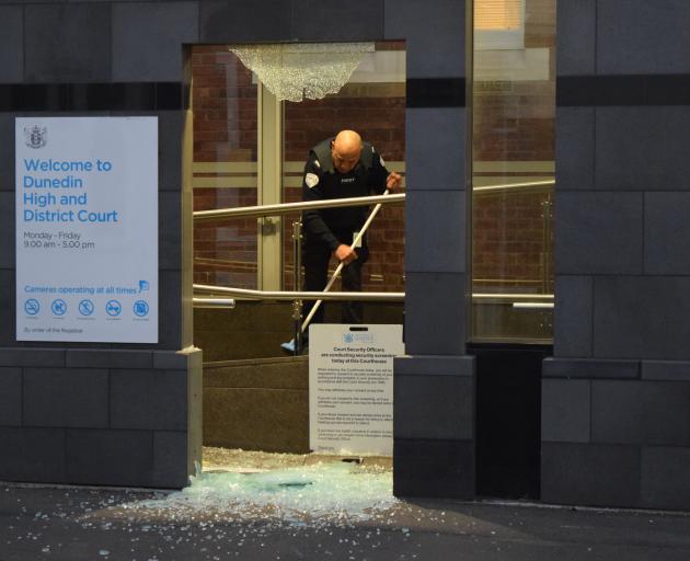 A staff member cleans up broken glass. Photo: Shawn McAvinue