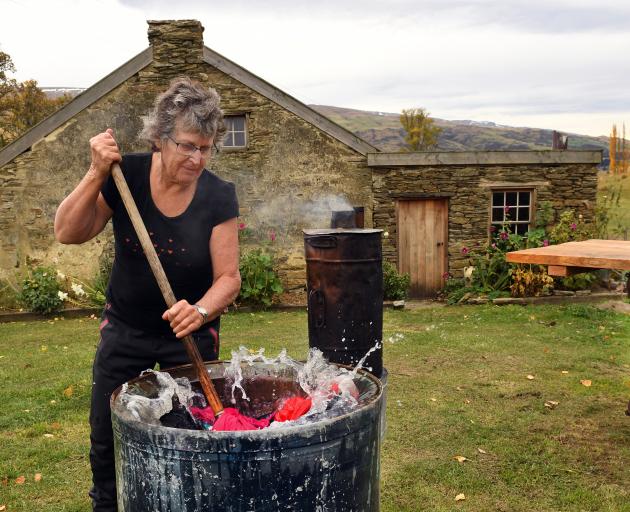 Lou Farrand washes her clothing in a copper boiler at her historic cottage near Roxburgh. She has...