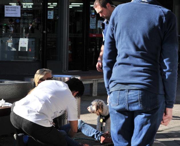 Pharmacist Chin Loh helps a customer who was bitten by another customer's dog outside the...