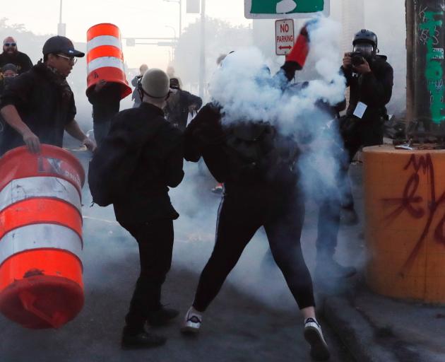 A protester throwing tear gas during continued demonstrations in Minneapolis on Monday. Photo:...