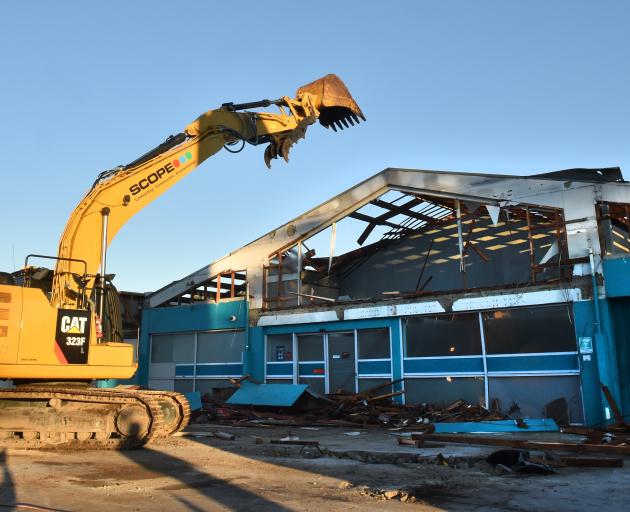 A Scope demolition digger starts to take down the Great King St Caltex site yesterday morning....