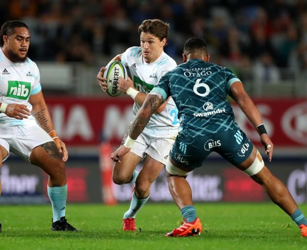 Shannon Frizzell of the HIghlanders lines up to tackle Beauden Barrett of the Blues in a nail...