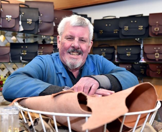 Bill Drake in the Rattray St store in 2015, with a full display of satchels behind. 
...