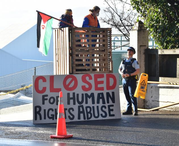 A police officer speaks to protesters at the Ravensdown fertiliser plant in Dunedin yesterday....