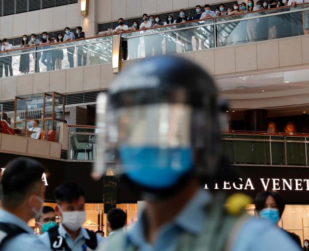 Riot police patrol at a shopping mall during a protest after China's parliament passes a national...