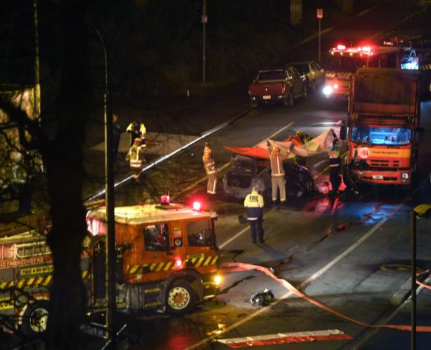 Firefighters assist at the scene of a double fatality crash between a car and a truck near a...
