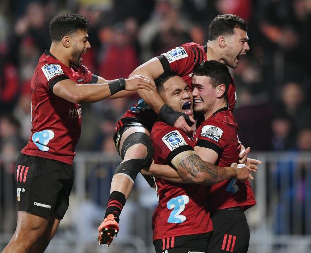 Will Jordan (right) is mobbed by his Crusaders teammates after scoring against the Blues in...