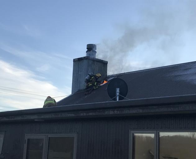 Firefighters work to put out a chimney fire in the Wrinkly Rams, Oamarama. Photo: Supplied