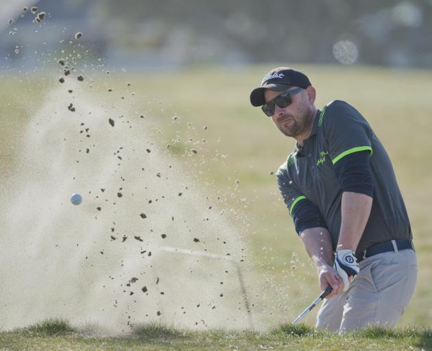 Island Park’s Michael Smith escapes the greenside bunker on the third hole at Chisholm Links on...