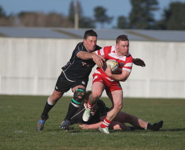 Clutha outside back Matt Barton looks to run away from the Clinton defence at the Balclutha...