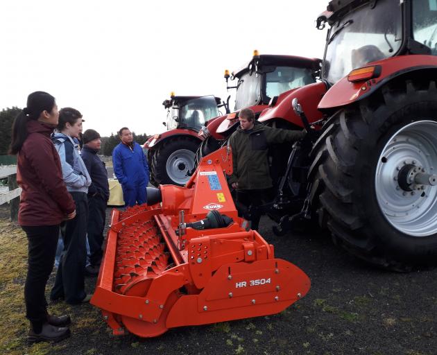 Students listen to tutor David Toole (right) discussing rural contracting equipment during a...