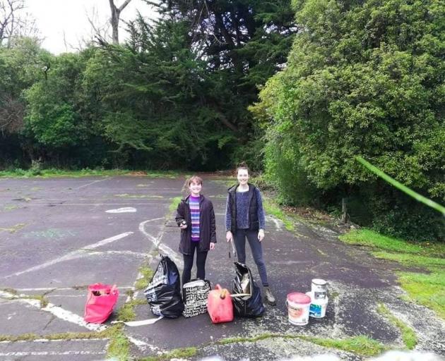 Miss Moss-Mason (left) and club secretary Ashlee Drummy display rubbish recovered from a site...