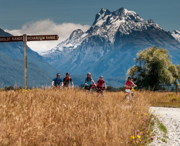 Cosmos Peak towers over cyclists en route to Paradise. PHOTO: LAURENCE BELCHER/PARADISE PICTURES