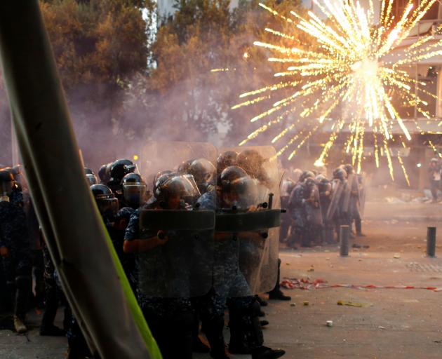 Fireworks are set off in front of police as anti-government protests continued in Beirut on...