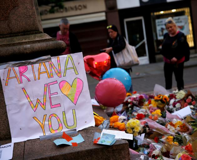 People look at flowers for the victims of the Manchester Arena attack. Photo: Reuters