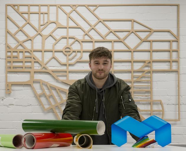 Miller Studios production manager Oliver Kloogh, who is standing in front of a map of Dunedin...