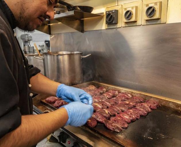 Assistant chef Alex Mahral cooks pūkeko on the hotplate. Photo: Fish & Game New Zealand