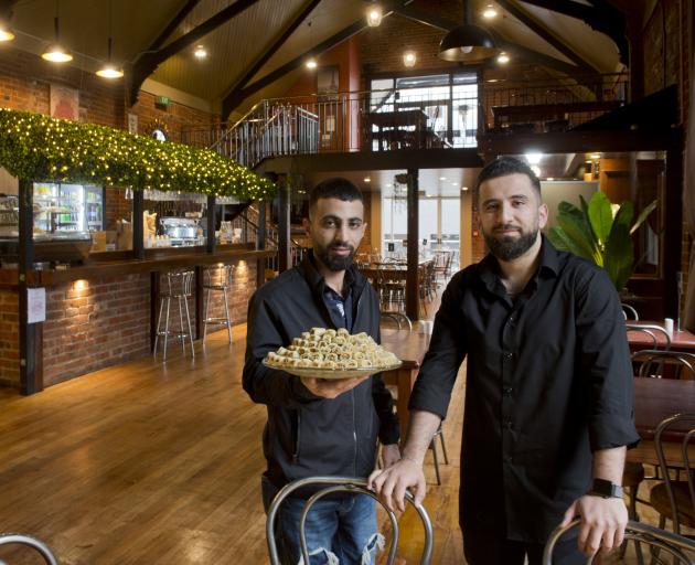 Al Sultan restaurant owner Mohammad Saad Aldeen holds some baklava while standing alongside his...