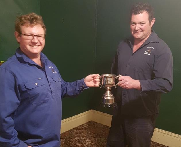 Millers Flat Rodeo Club secretary Mark Booth (left), of Ettrick, receives his trophy from club...