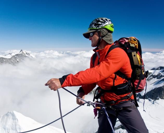 Paul Hersey belays (secures) another climber on a glacier between Mt Walter and Mt Green in...