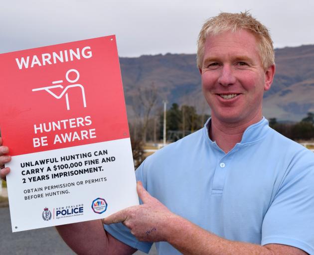 Constable Allan Lynch, of Middlemarch, displays a sign warning against illegal hunting after...