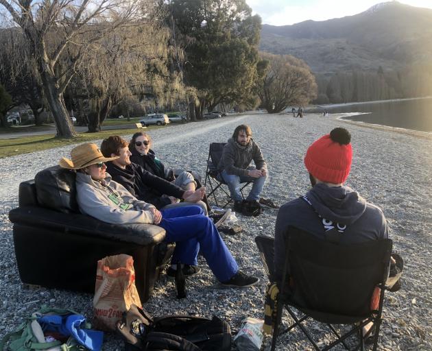 Watching the sun set from the Lake Wanaka foreshore on Saturday are (from left) Leo Bananche (23)...