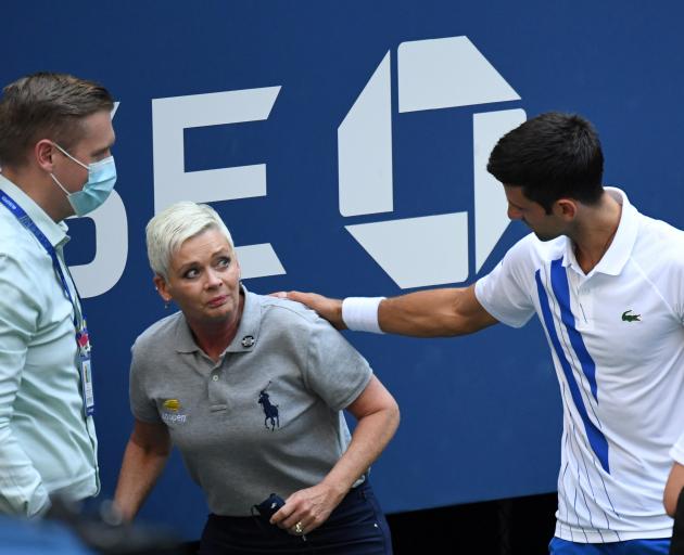 An apologetic Novak Djokovic (right) and a tournament official tend to a lineswoman struck with a...