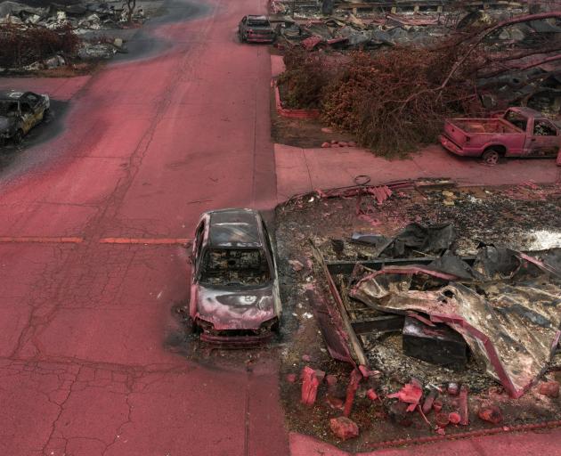 Red fire retardant blankets burned residences and vehicles in the aftermath of the Almeda fire in...