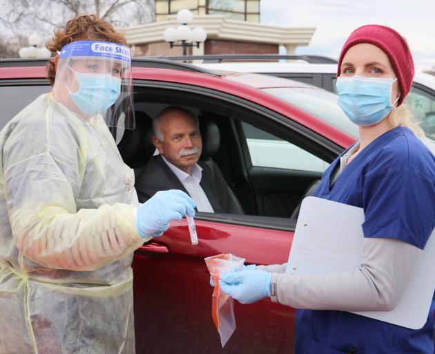 WellSouth nurse Rachel Hall (left) places the swab collected from Gore Mayor Tracy Hicks in the...