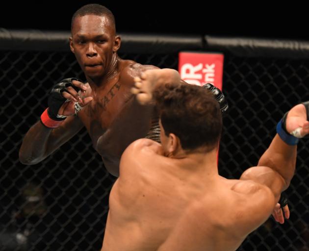 Israel Adesanya lands a kick to the head of Paulo Costa. Photo: Getty Images