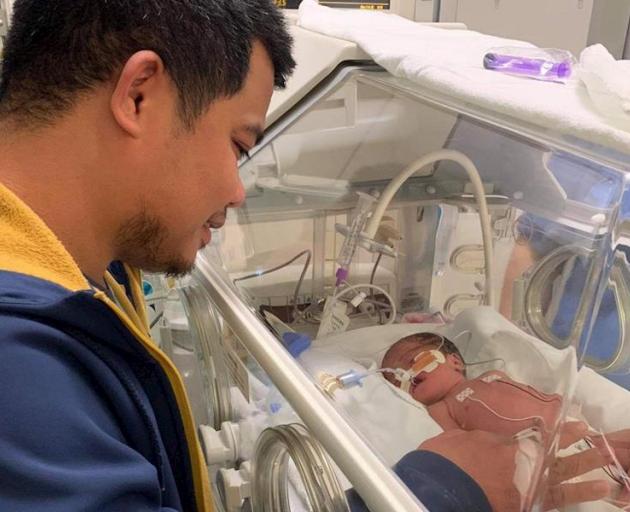 Heylon Sevilla, with son Nio (5), keeps a watchful eye on newborn daughter Estella Marie while he...