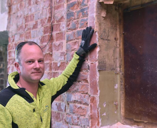 Highland Homes foreman Kyle Pomeroy with some interesting prints found in the wall of the old...