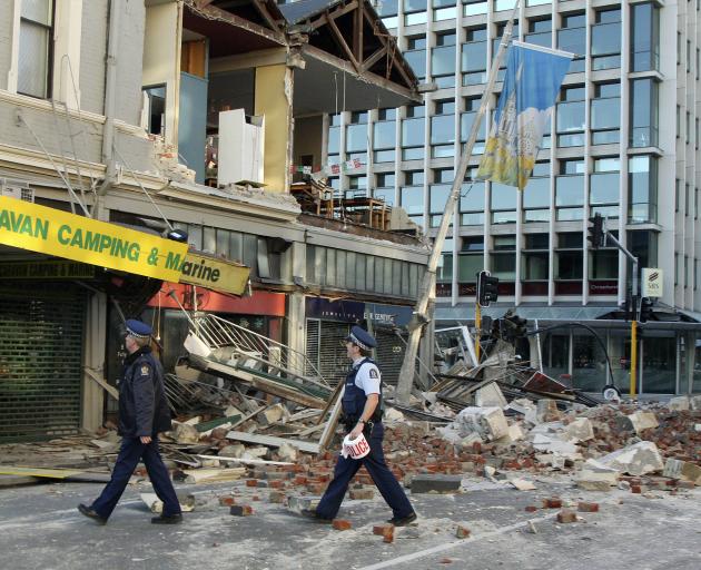 Police inspect damage to a building on the corner of Manchester and Worcester Sts. Photo: Geoff...