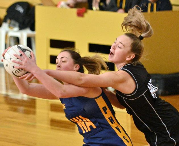 Physed A’s Emily Henderson clutches the ball as Southern Magpies’ Bridie Burns tries to snatch it...