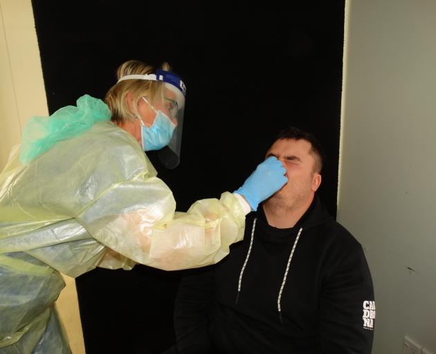 Queenstown Medical Centre nurse Caroline Hughes takes a swab from Tom Cunnington at a Covid-19...