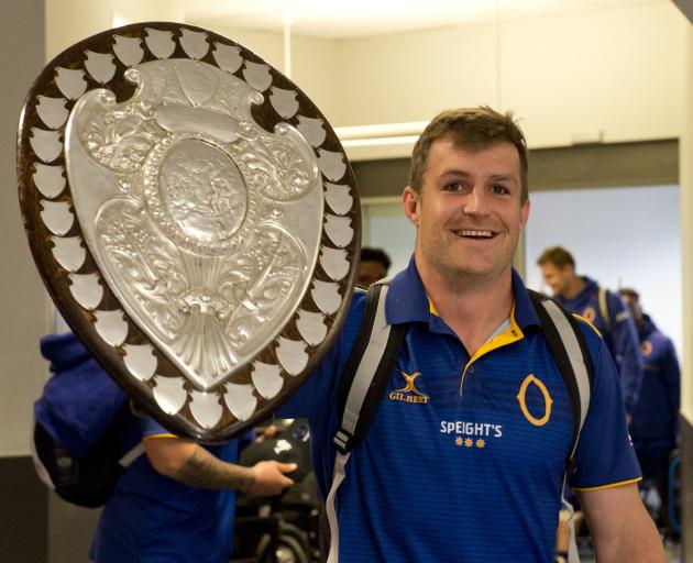 Otago captain Michael Collins brings the Ranfurly Shield with him through Dunedin Airport...