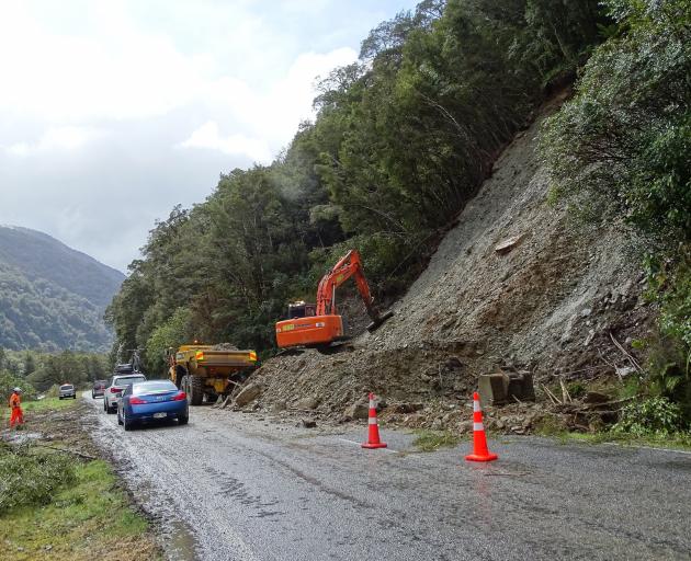 Road crews continued to clear away mud from the slip at Burke Flat as the first cars drove north...